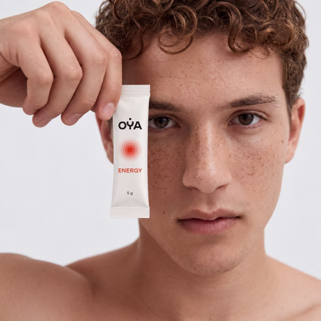 A man holding an OYA ENERGY stick to his face